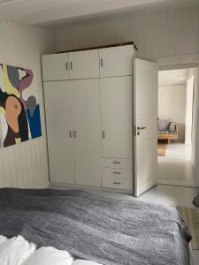Schlafzimmer mit weißen Schränken und einem Bett in der Unterkunft Cozy cottage in Stockholm Archipelago! in Muskö