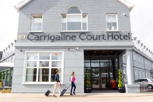 two people walking in front of a building at Carrigaline Court Hotel & Leisure Centre in Cork
