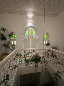 a white staircase with a window and some plants at Dija Riad in Asilah +39 photos