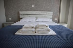 two towels on a bed with two pillows at 4Keys Apartments Nikiti in Nikiti