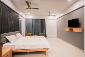 a bedroom with a bed and a flat screen tv at Silver waves beach stay in Mūlki
