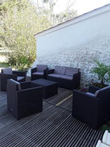 a patio with couches and plants next to a wall at La Longère des Basses Terres in La Garnache +6 photos