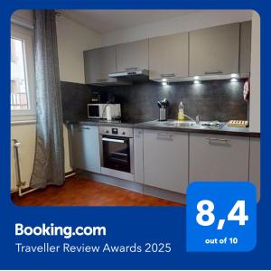 a kitchen with white cabinets and a stove top oven at Les Charpentiers in Colmar