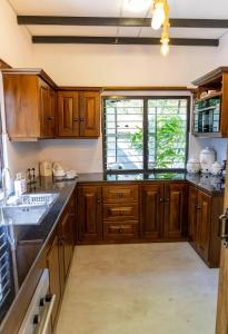 a kitchen with wooden cabinets and a sink at New! Mangalam house, Private plunge pool near beach in Trincomalee