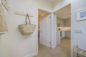 una cocina con puerta y una cesta en la pared en The Pink House, Salcombe, with Free Parking, en Salcombe 37 fotos más