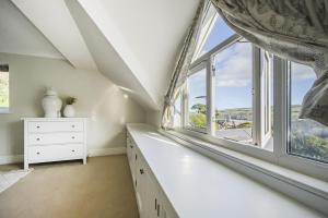 Habitación en el ático con ventana grande y cómoda blanca en The Pink House, Salcombe, with Free Parking, en Salcombe