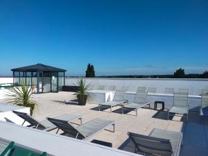 a group of chairs and a gazebo next to the water at Adonis La Baule in La Baule