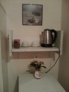 a shelf with a tea kettle and dishes on it at Chris Apartments Corfu - Studio without kitchen in Alepou