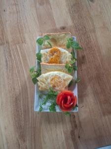 a plate of food with sandwiches on a wooden table at BamBoo Villa Homestay in Ninh Binh