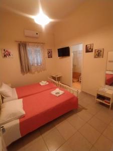 a bedroom with a red bed in a room at Chris Apartments Corfu - Studio without kitchen in Alepou +6 photos