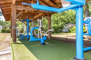 une aire de jeux avec des balançoires bleues et blanches dans l'établissement Camping Le Soleil des Landes, à Lit-et-Mixe