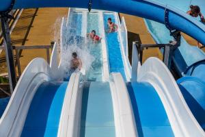 a group of people riding a water slide at a water park at Camping Le Soleil des Landes in Lit-et-Mixe