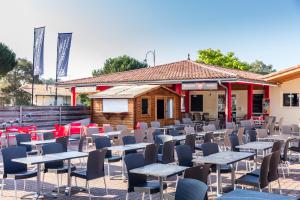 a group of tables and chairs in front of a building at Camping Le Soleil des Landes in Lit-et-Mixe +31 photos