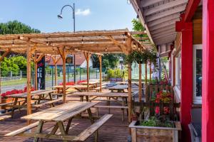a group of picnic tables on a wooden deck at Camping Le Soleil des Landes in Lit-et-Mixe