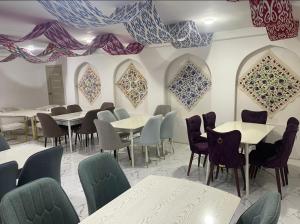 un ristorante con tavoli, sedie e quadri alle pareti di Mahdiy a Khiva