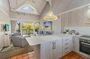 a kitchen with a large white counter and a living room at Knysna - Somerschoon Tulip Retreat in Knysna