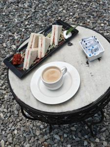 a cup of coffee and a plate of cake on a table at Treetop Glamps in Mussoorie +35 photos