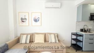 a living room with a couch and a kitchen at Atico Melosas - Alojamientos La Torre in Torre del Mar +19 photos