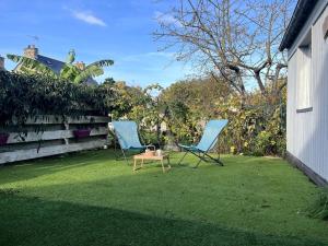 two chairs and a table on a lawn at Petite maison de plein pied in Saint Malo