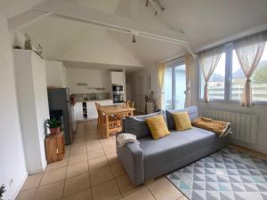 a living room with a couch and a kitchen at Petite maison de plein pied in Saint Malo