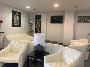 a living room with white couches and a table with a lamp at Adonis La Baule in La Baule