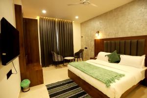 ein Schlafzimmer mit Bett, Fernseher und Tisch in der Unterkunft Hotel Dhingra Inn in Rewāri
