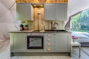 a kitchen with a sink and a stove in a tent at Woodland dome in Thornbury