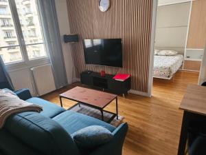 een woonkamer met een blauwe bank en een tv bij View sur la Seine in Parijs +15 foto's