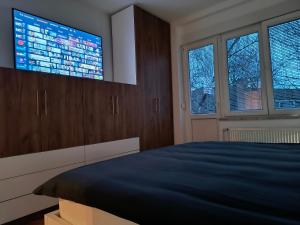 a bedroom with a bed and a flat screen tv at Apartman Wolf in Varaždin