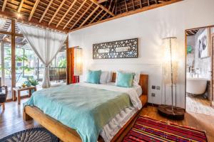 a bedroom with a large bed and a bathroom at Modern Joglo Villas in Canggu 5 Bedrooms in Kerobokan +51 photos