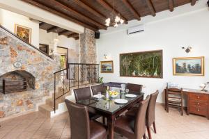 a dining room with a table and chairs and a fireplace at Villa Melina in Tavronitis