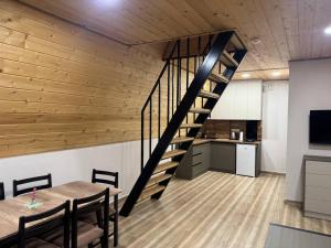 a staircase in a room with a table and a kitchen at Karapetyans Guest House in Stepʼanavan