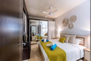 a bedroom with a large bed with a yellow blanket at Grand Baie Domaine des Alizes in Grand Baie +26 photos