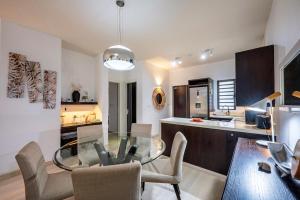 a dining room and kitchen with a glass table and chairs at Grand Baie Domaine des Alizes in Grand Baie