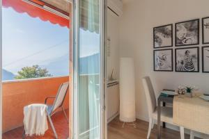 a room with a balcony with a table and chairs at Roberta s Home in Perledo