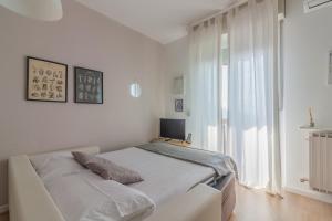 a white bedroom with a bed and a window at Roberta s Home in Perledo +44 photos