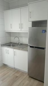 a kitchen with white cabinets and a stainless steel refrigerator at Alfazema Alojamento Local in Angra do Heroísmo +7 photos