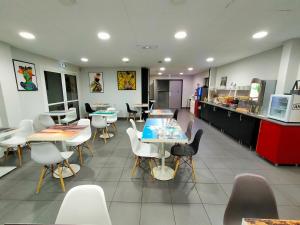 a restaurant with tables and chairs and a kitchen at Adonis La Baule in La Baule