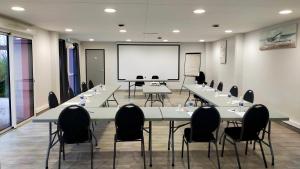 a meeting room with tables and chairs and a whiteboard at Adonis La Baule in La Baule