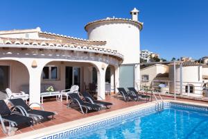 a villa with a swimming pool and patio furniture at Villa Diana in Benitachell