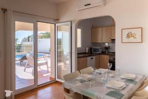 a dining room with a table and a kitchen with a patio at Villa Diana in Benitachell