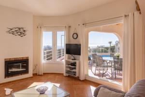 a living room with a fireplace and a television at Villa Diana in Benitachell
