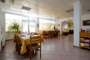 a dining room with tables and chairs with yellow table cloth at Pension Silvia in Međugorje