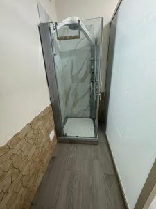 a walk in shower in a room with a wooden floor at B&B Camilla in Conca della Campania