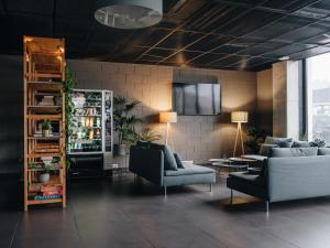 a living room with couches and a tv on a wall at Eduard House by Larsen in Tallinn