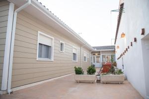 孔苏埃格拉Azafrán Consuegra的一条种植了植物的建筑旁的走道
