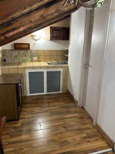 a small kitchen with wooden floors and a counter top at Mansarda IGUANA in CTA +5 photos
