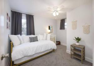 a bedroom with a white bed and a ceiling fan at Family Friendly 4 BR Home Close To Downtown CLE! in Cleveland