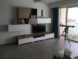 a camera in a living room with a television and a tripod at NEW Apartment with sunset views and pool in Żebbuġ