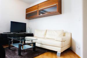 a living room with a white couch and a glass table at Elegant Vienna Apartment in Vienna